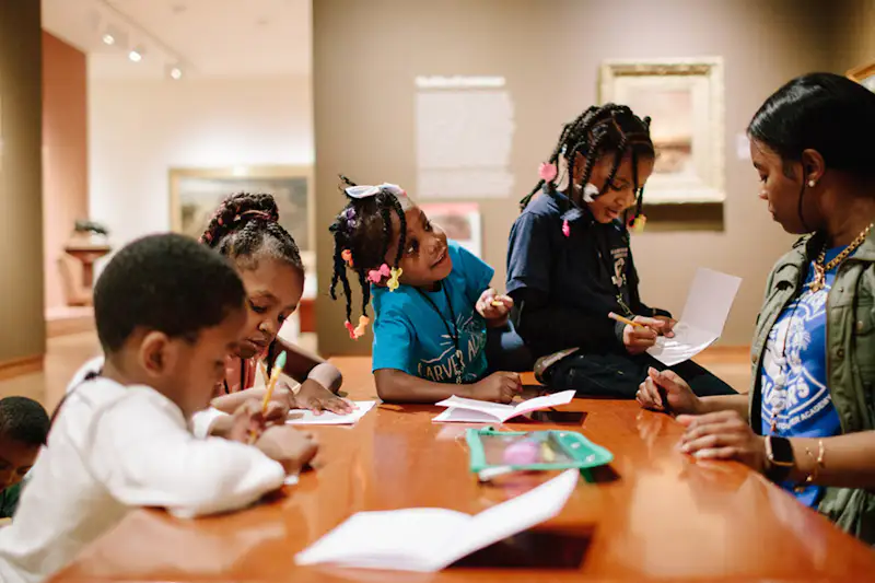 Group of younger children drawing with pencils