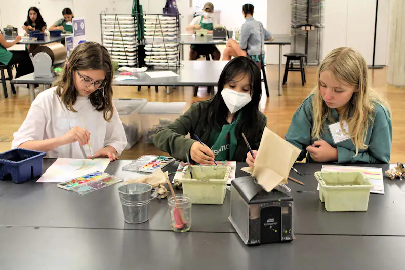 Three young girls creating art together