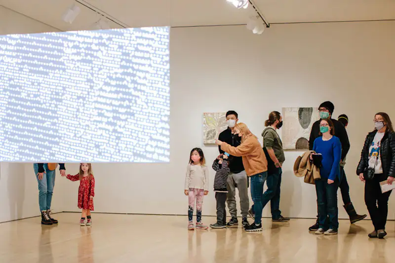 Small group looking at a piece of mixed-media art