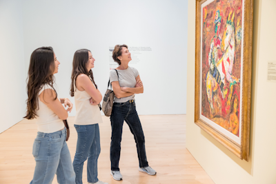 A family of four stands at the edge of Windover Hall and look up at the architecture in admiration.